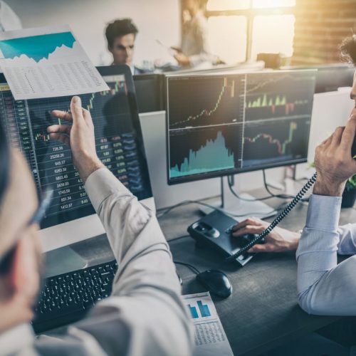 Investment graphs on laptop screens